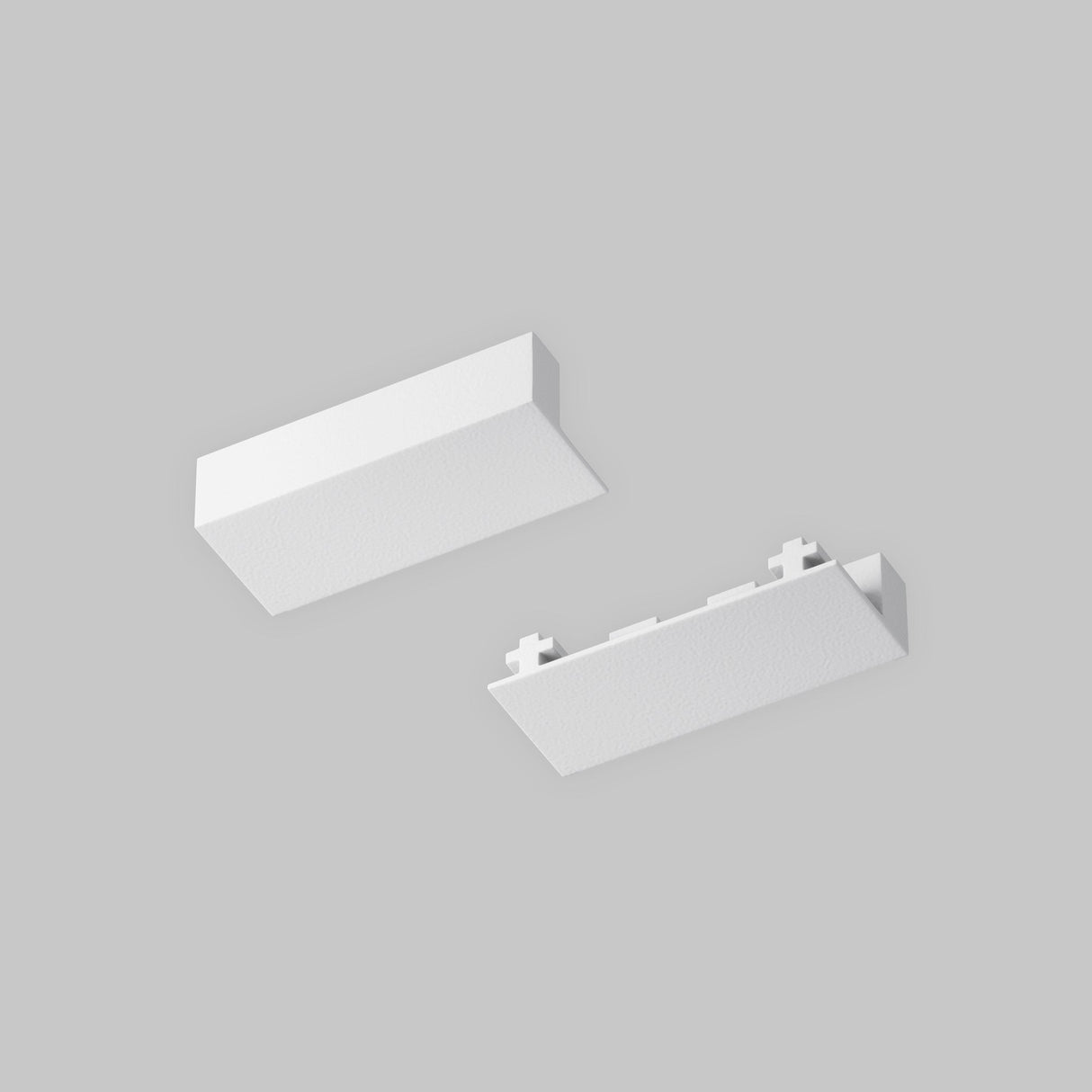 Two white textured rectangular objects appear against a gray background. The top one showcases the Radity Magnetic Surface-Mounted Track, while the bottom has an end cap with small protrusions along one edge, both in sleek white.