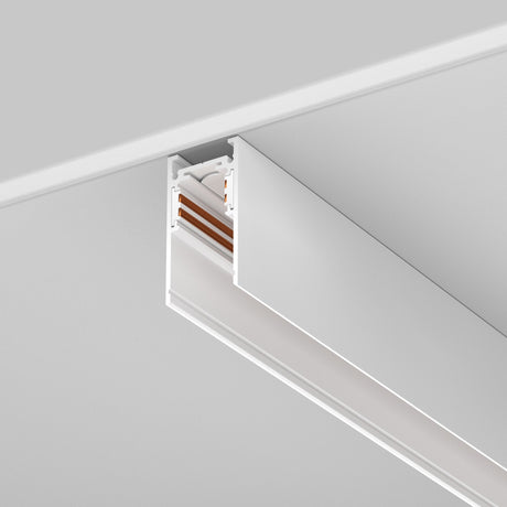 The Exility Magnetic Surface-Mounted Track 1m - White is installed on a white ceiling, featuring a sleek, minimalistic design with a rectangular shape and copper-colored internal components visible at one end.