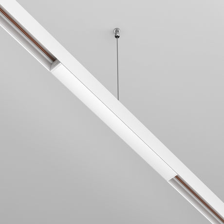 The Exility Recessed Track Power Supply 100W in white features a sleek, elongated design suspended by a thin metal rod from a gray ceiling, blending modern aesthetics with functionality for an energy-efficient solution that ensures style and sustainability.
