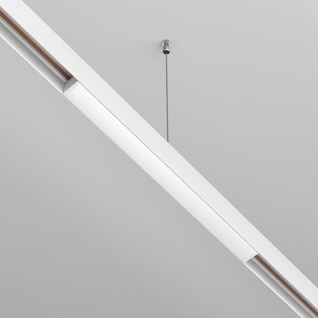 The Exility Recessed Track Power Supply 200W in white powers a sleek, modern linear light fixture that hangs from the ceiling with a single cable. Its minimalist design showcases clean lines and a neutral color palette against a plain light gray ceiling.