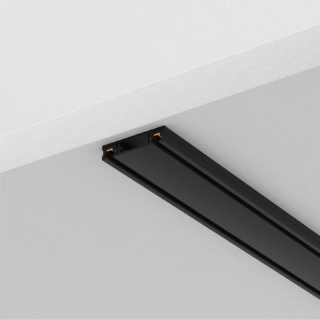 The Radity Magnetic Surface-Mounted Track 1m in black is installed on a white ceiling, offering sleek modern elegance. It seamlessly integrates into the ceiling design with versatile, customizable lighting layouts perfect for any space.