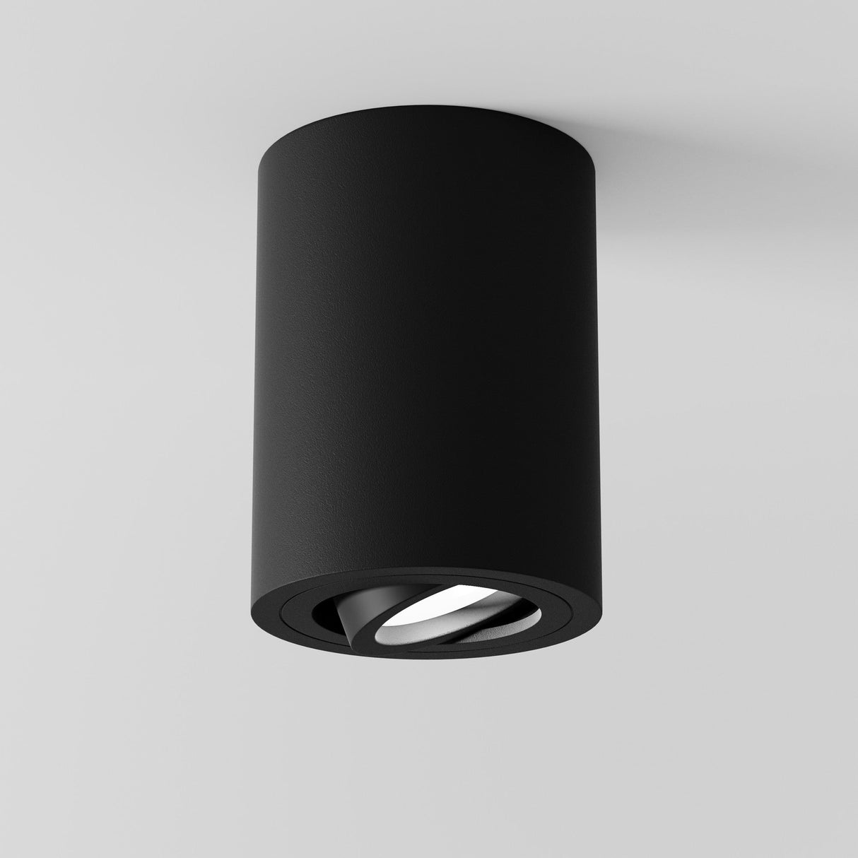 The Atom Round Surface Mounted Downlight in black is a minimalist, cylindrical fixture designed for ambient lighting against a white background.