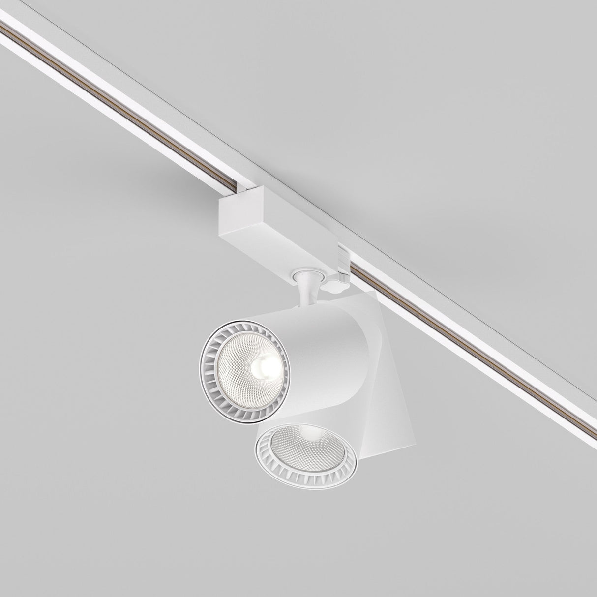 The Vuoro S 3-Circuit Trinity Track LED Spotlight 20W 4000K in white features two adjustable cylindrical fixtures on a ceiling rail, providing a focused and energy-efficient beam.
