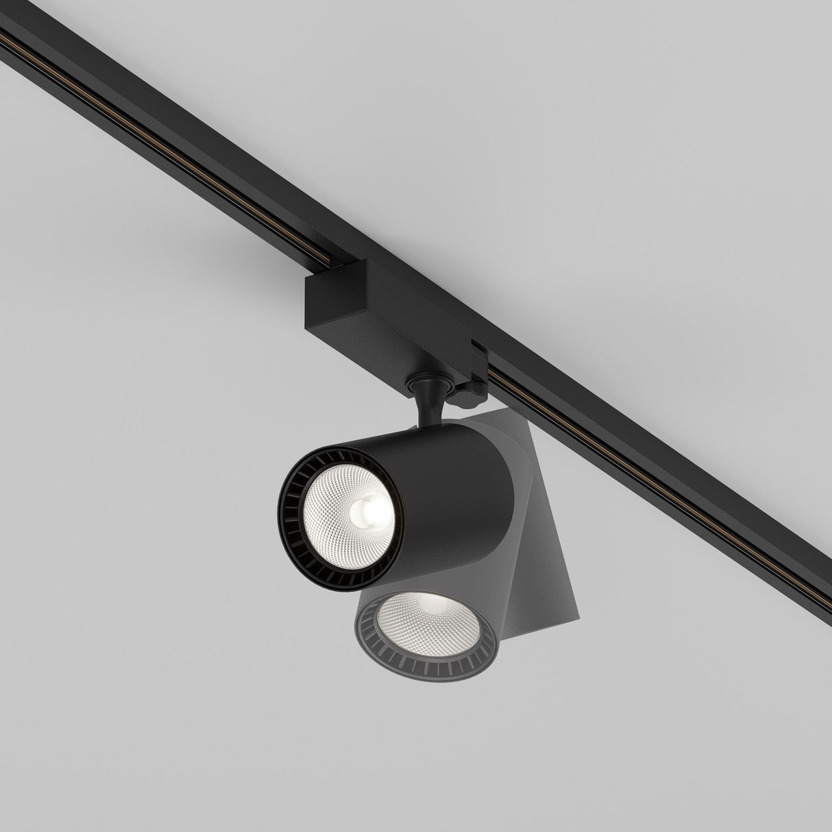 The Vuoro S 3-Circuit Trinity Track LED Spotlight, 26W in black with a cylindrical design and aluminum finish, mounts sleekly on the ceiling with two LED spotlights providing focused illumination against a light gray background.