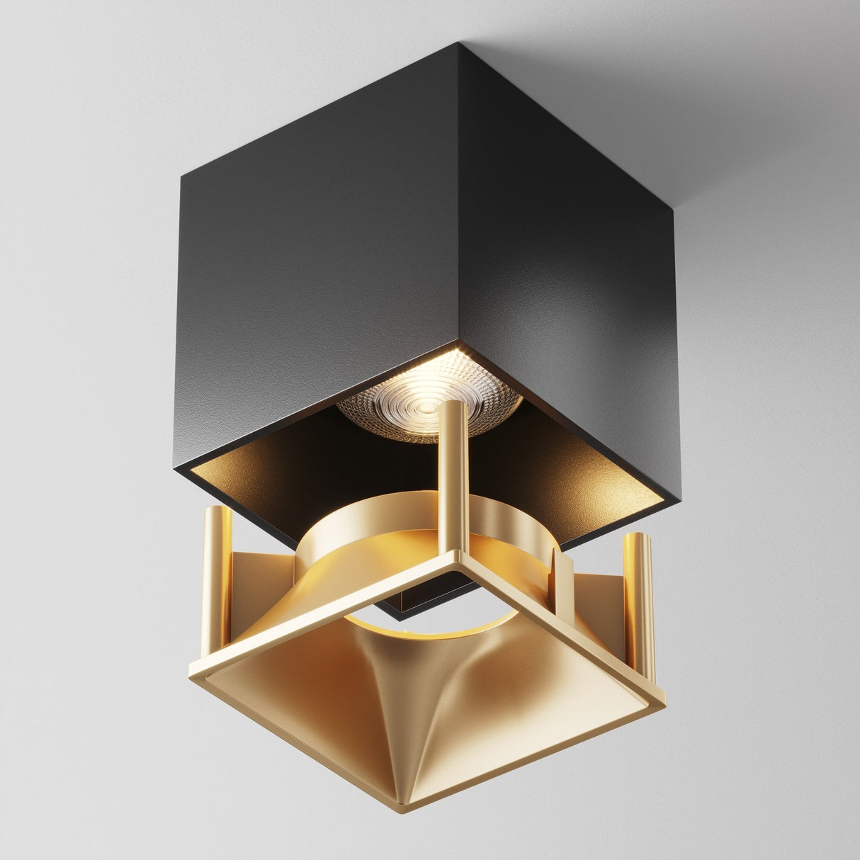 The Alfa LED Square Decorative Reflector Frame features a black square base with a gold geometric design. Its matte gold reflector adds depth and casts a soft glow, creating a stylish contrast against the plain white background.