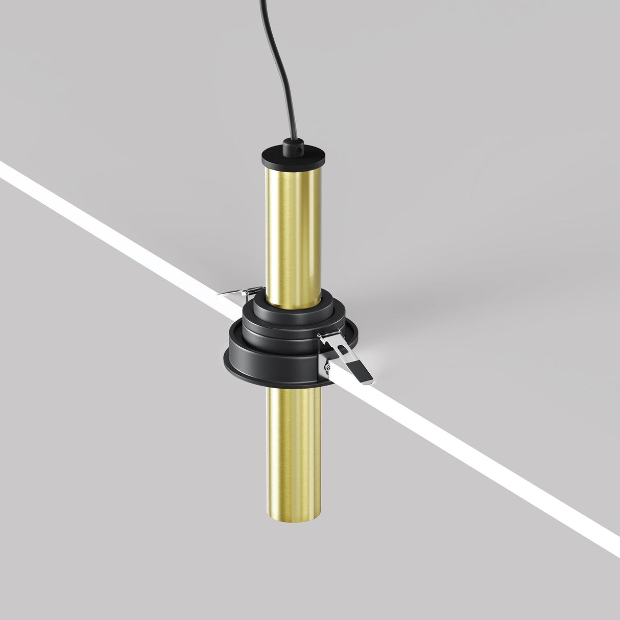 A cylindrical Focus T LED Downlight, gold and black with a cord, hangs from a gray ceiling. Its modern design and sleek base brackets add industrial charm as a Black & Brass Fixture.