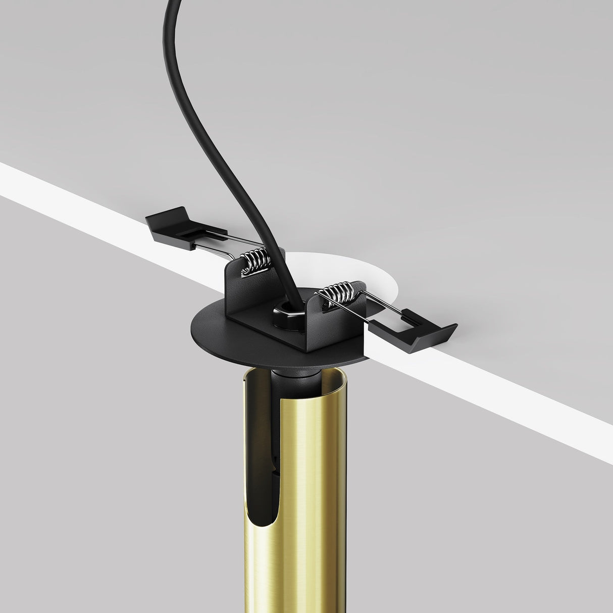 The Focus T LED Adjustable Short Recessed Downlight 6W 3000K in Black & Brass features a cylindrical gold support with a spring-loaded black cable clip for sleek cable management beneath a white desk.