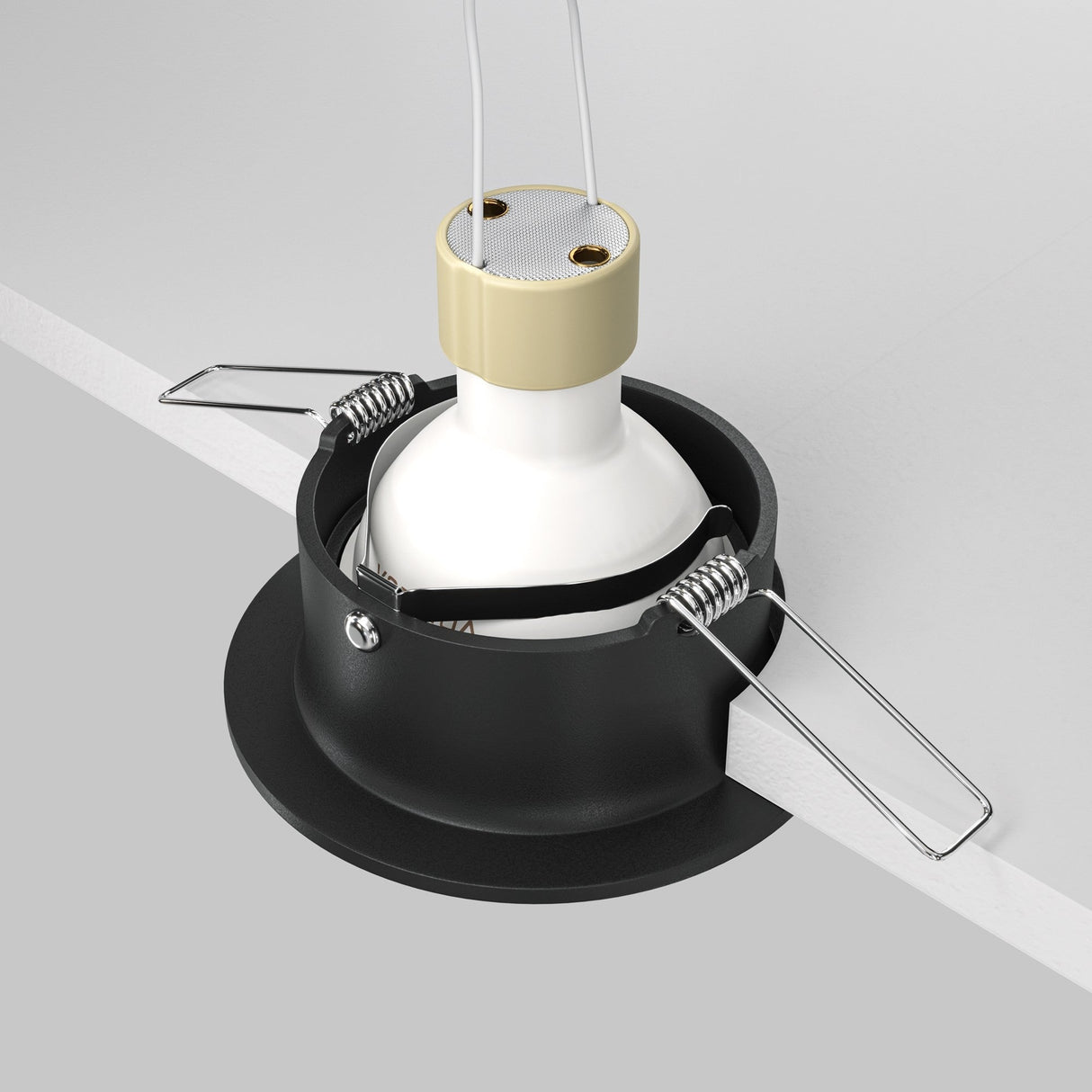 The Slim Fixed Round Recessed Downlight - Black features a white bulb in a beige casing within a black circular holder, elegantly designed with metal spring clips for easy installation, highlighting its minimalist aesthetic.