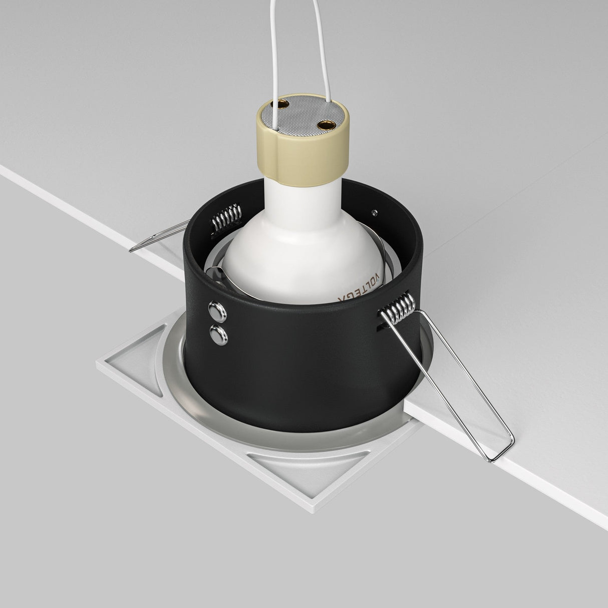 A close-up of the Zoom Single Fixed Square Recessed Downlight - White being installed in a ceiling highlights its minimalist design, emphasized by metallic clips and a white bulb socket. The visible wires suggest secure installation, promising an IP65 rating for reliability.