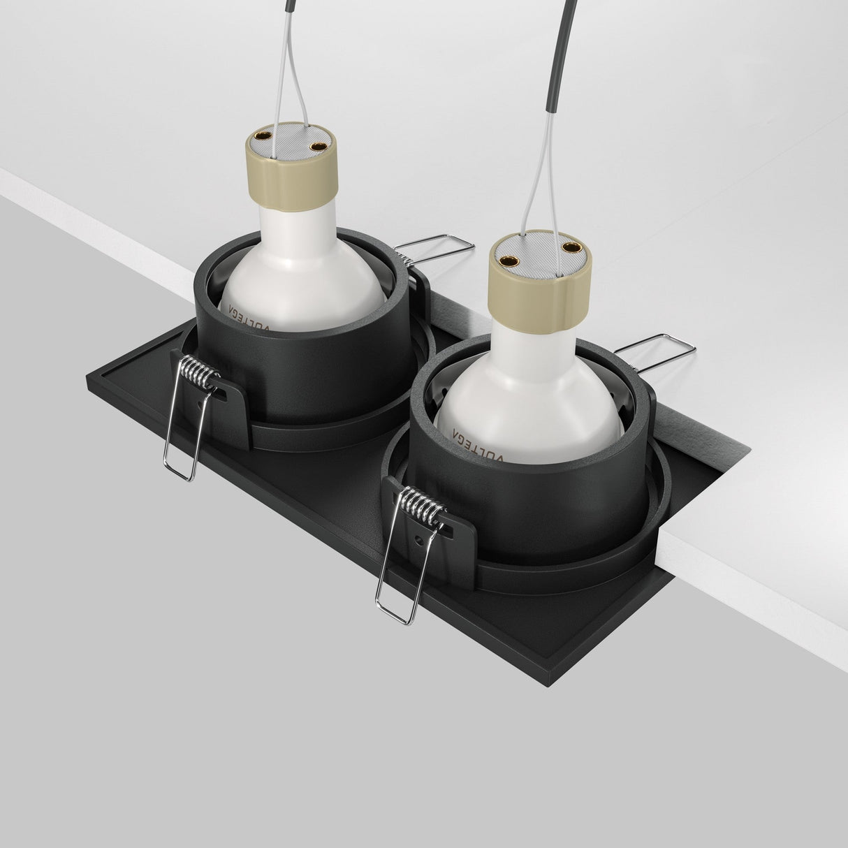 The Zoom Twin Fixed Rectangular Recessed Downlight - Black features IP65-rated fixtures with black casings and white bulb sockets, secured by metal clips. Positioned side by side on a white surface, they are seamlessly connected by wires.