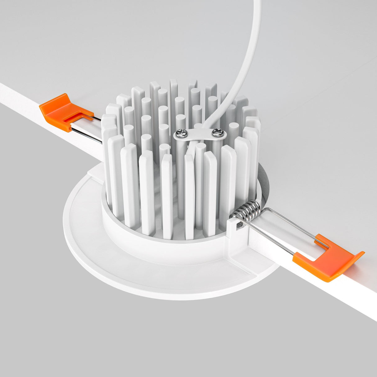 Close-up of the Zen LED Round Recessed Downlight 7W 4000K - White, featuring a circular design with an intricate heatsink, attached wires, and two orange spring-loaded clips for secure installation in recessed lighting. This energy-efficient fixture is perfect for your lighting needs.