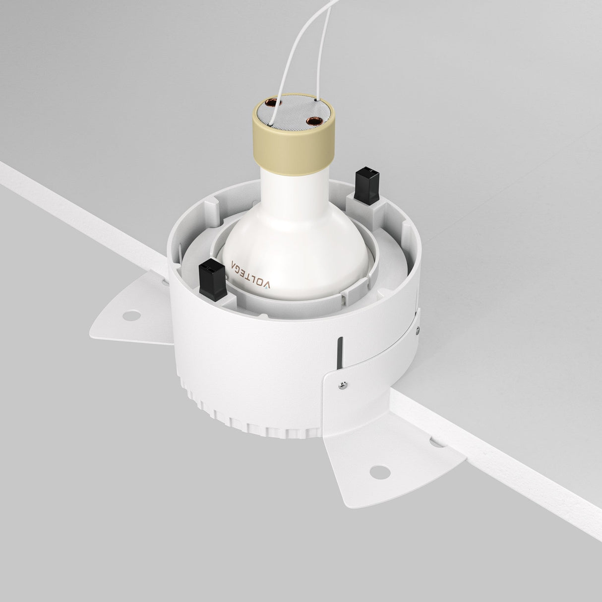 The Share Round Plaster-in Fixed Recessed Downlight - White is a minimalist, round cylindrical light fitting with visible installation brackets and two small black components. Labeled VOLTEGA, it extends from a ceiling tile, making it ideal for task lighting.