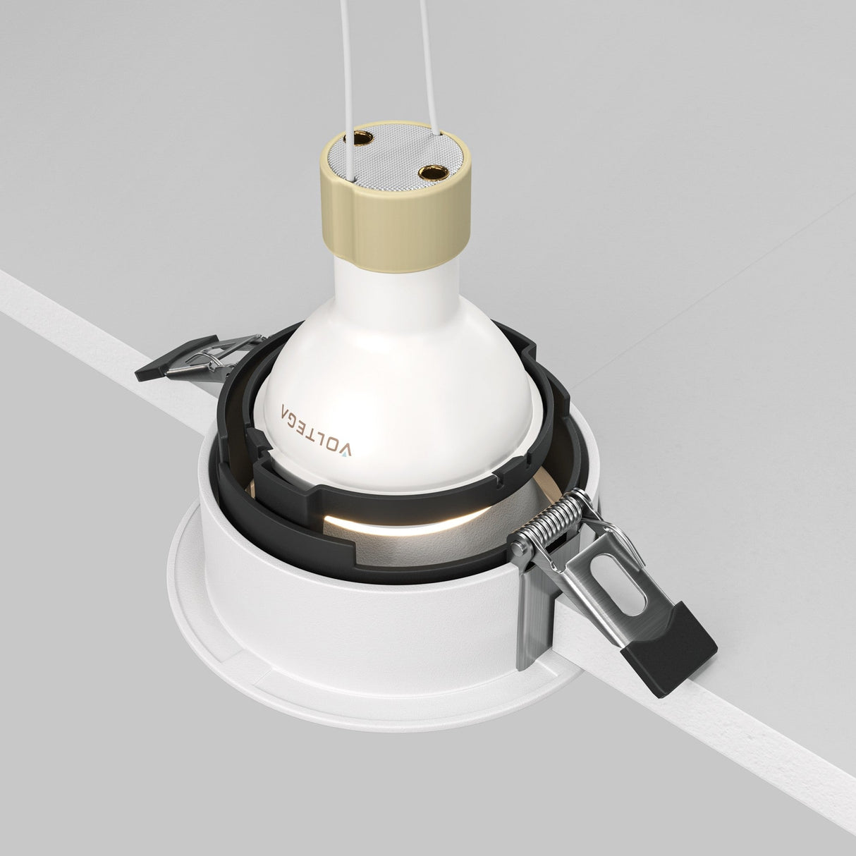The Share Round Recessed Swivel Downlight - White, featuring a minimalist design with a white and gold base and VOLTGA branding, is elegantly installed into a circular housing and secured by two metal clips against the white ceiling.