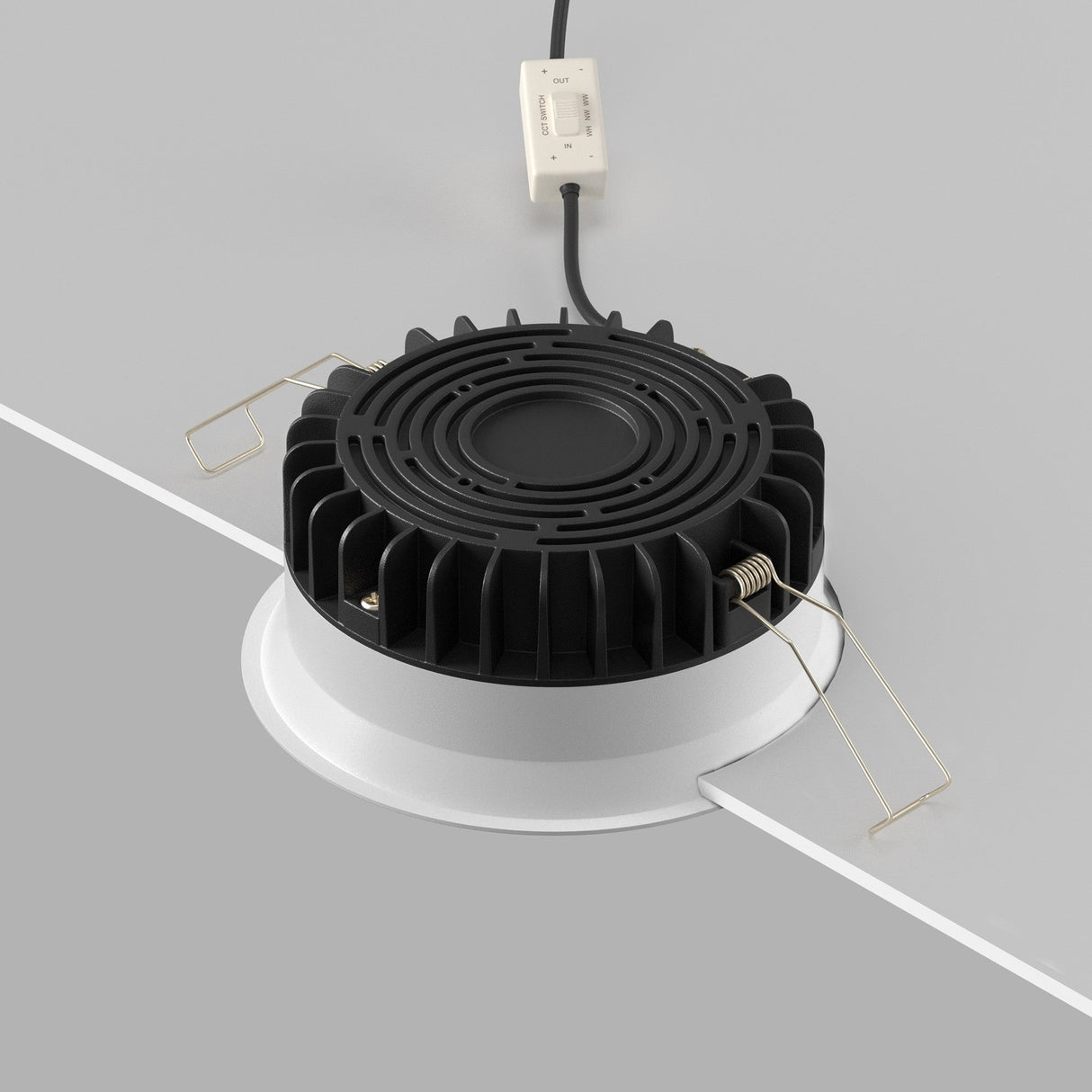 A partially installed Okno CCT LED Round Recessed Downlight 12W (3000-6000K) with ridged sides is seen in a white ceiling. It has adjustable color temperature, metal clips, and a cable with a white switch for energy-efficient illumination.