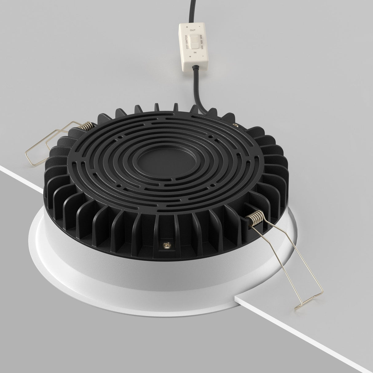 An Okno CCT LED Round Recessed Downlight 18W, color-adjustable from 3000-6000K, is partially installed in a ceiling cutout. It has cooling fins, two metal spring clips for secure placement, plus a black power cord with a white connector providing an efficient lighting solution.