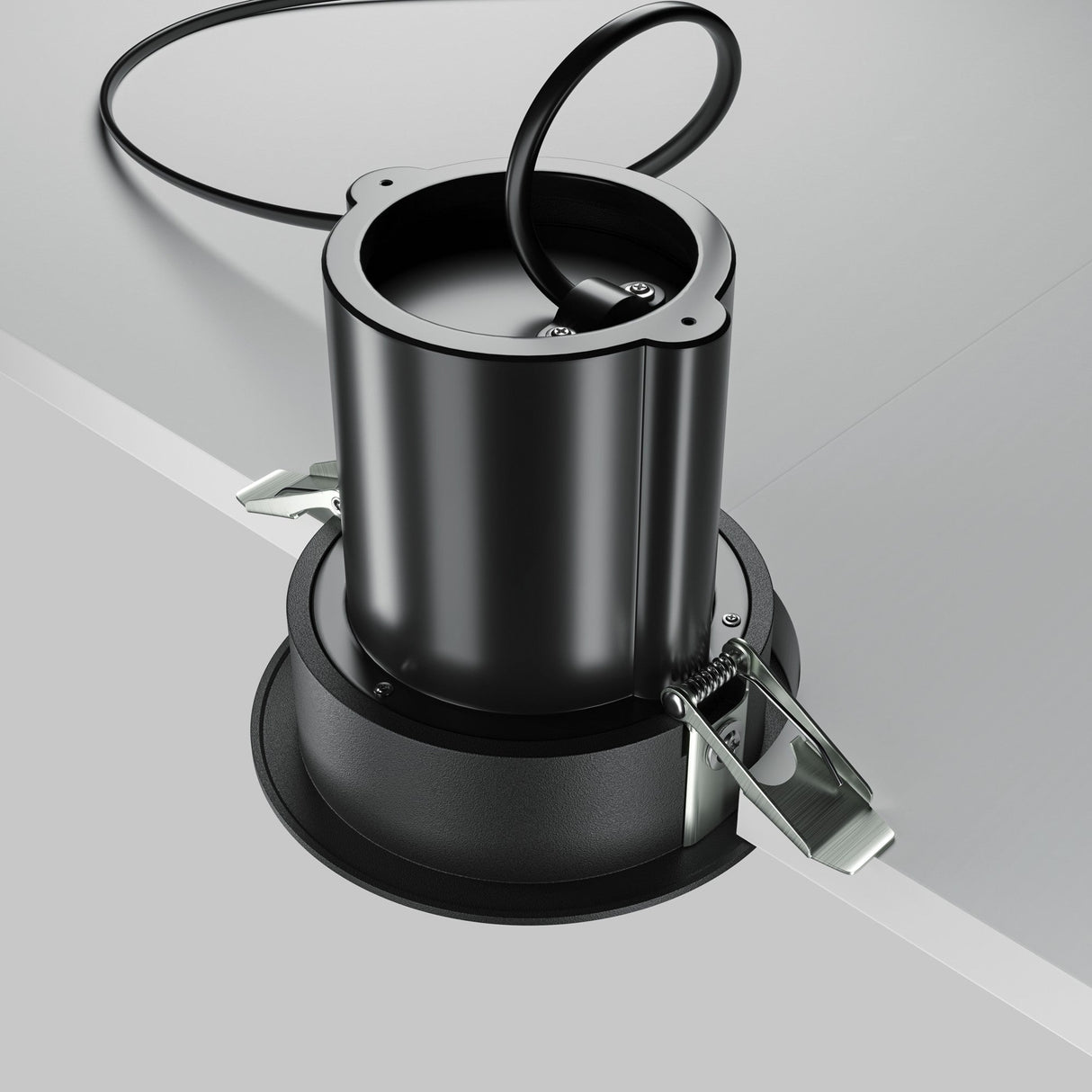 Showcased against a gray background, the Hidden Adjustable Retractable In-Out LED Recessed Downlight in black is cylindrical with an attached cord and metal side clips for easy installation, featuring energy-efficient LED technology.