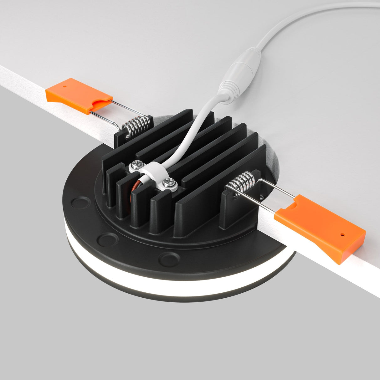 Equipped with two orange clips and a cable for easy installation, the Phanton LED Recessed Downlight 12W 3000K - Black features a sleek, ribbed design. It resembles an LED puck light, providing efficient illumination for any setting.