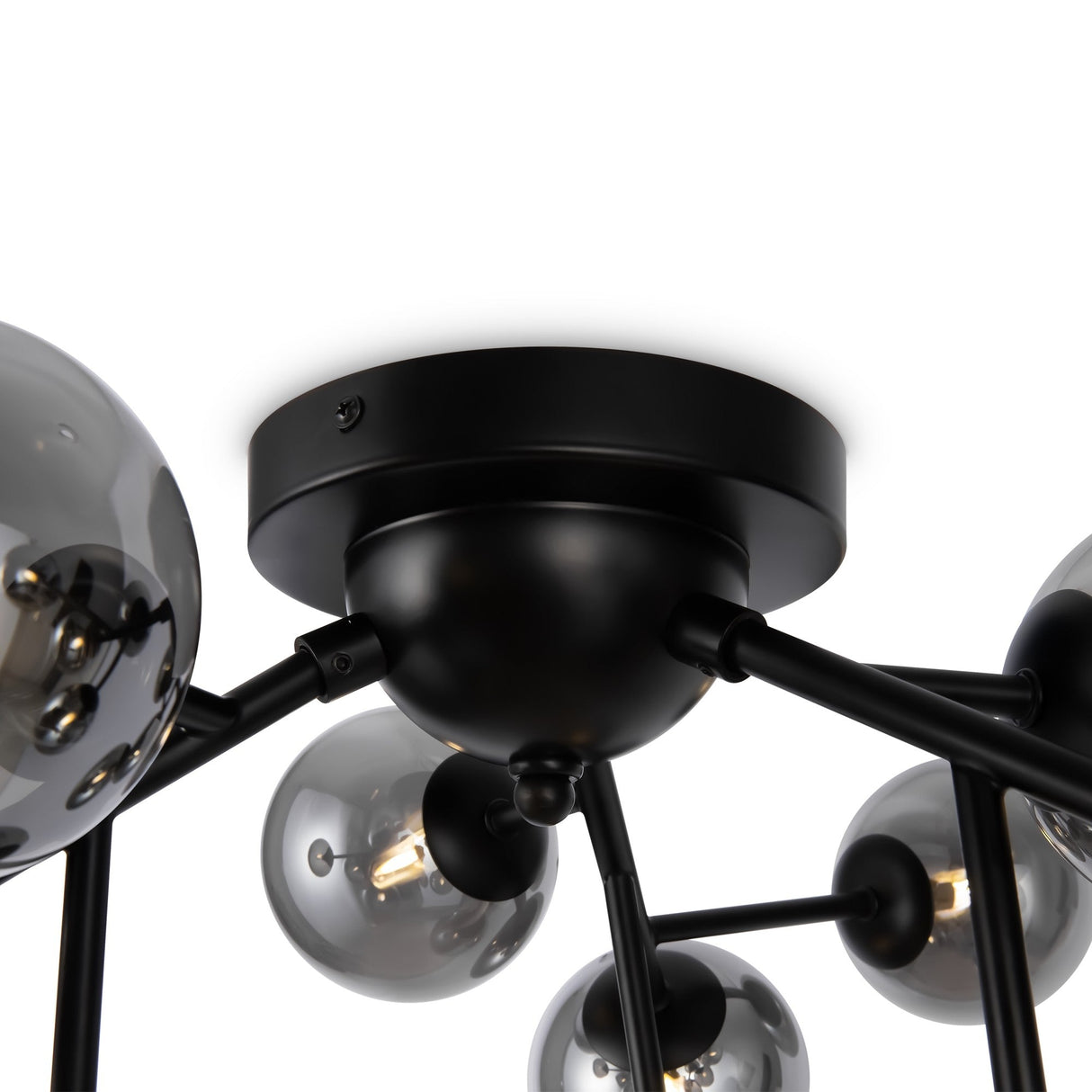 Close-up of the Dallas 12 Light Semi-Flush in black with smoked glass, featuring an industrial design. Visible filament bulbs are encased in glass globes connected to black rods radiating from a central base, making it a striking piece of contemporary lighting.
