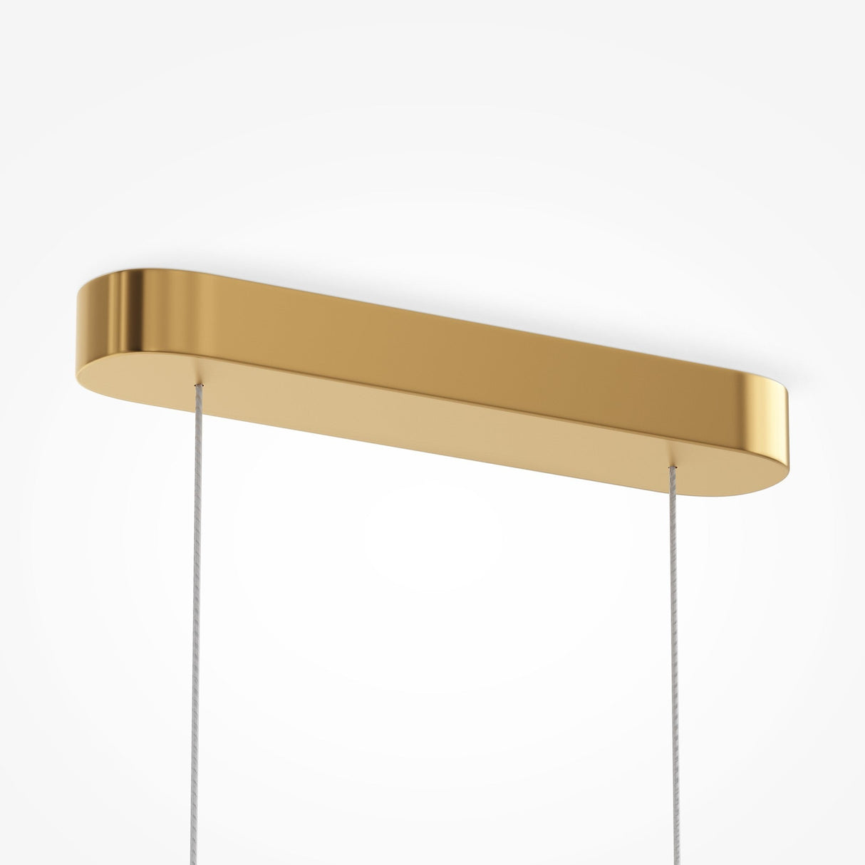 A modern Amulet LED Linear Suspension Light with a sleek, rectangular gold casing and ribbed glass hangs from the ceiling by two thin, adjustable cables against a plain white background, showcasing its minimalist design with smooth edges and a polished finish.