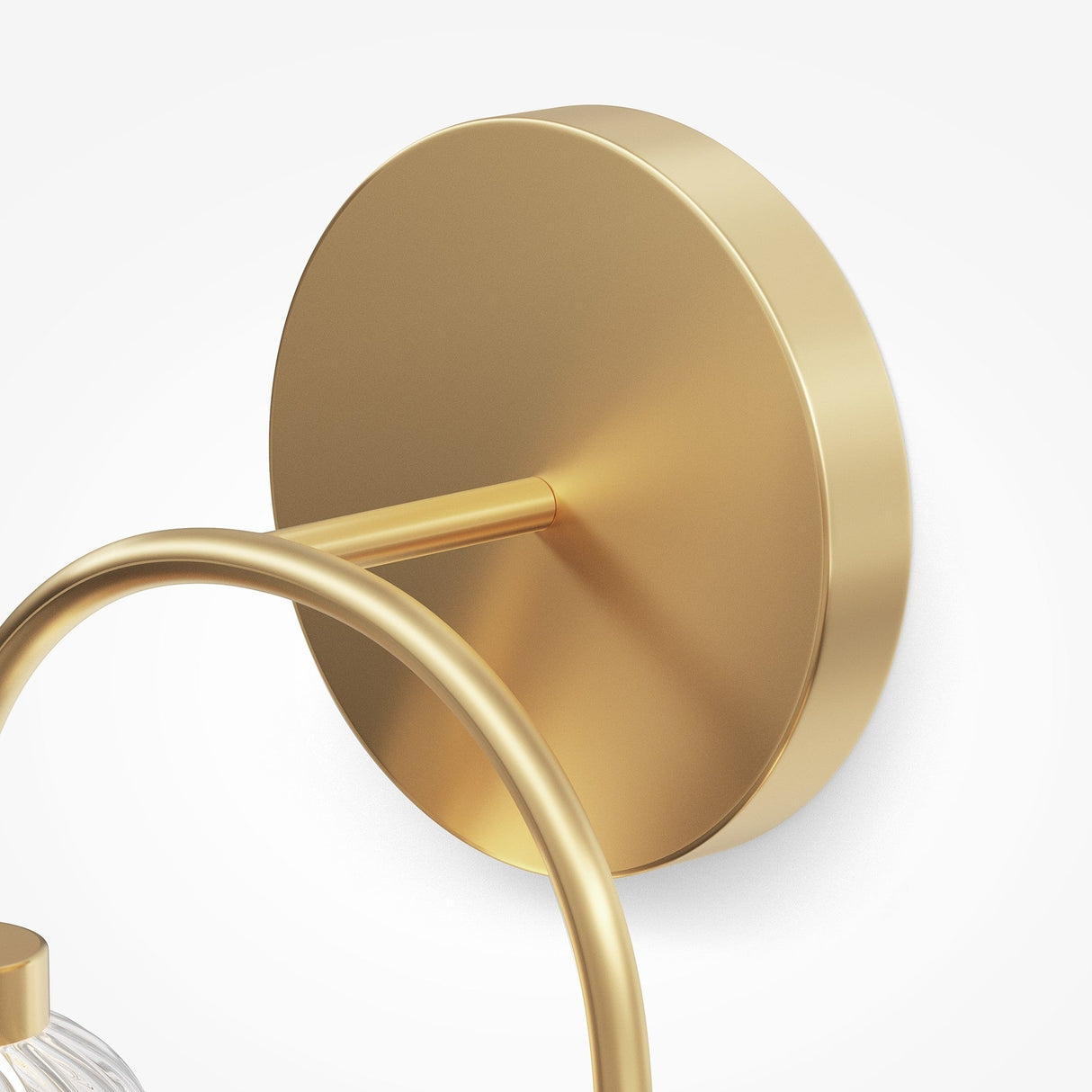 Close-up of the Amulet LED Loop Wall Light - Gold With Ribbed Glass Spheres, showcasing a modern brass wall bracket with a circular design, sleek rod, and polished metallic gold finish supporting cylindrical fixtures or ribbed glass spheres.