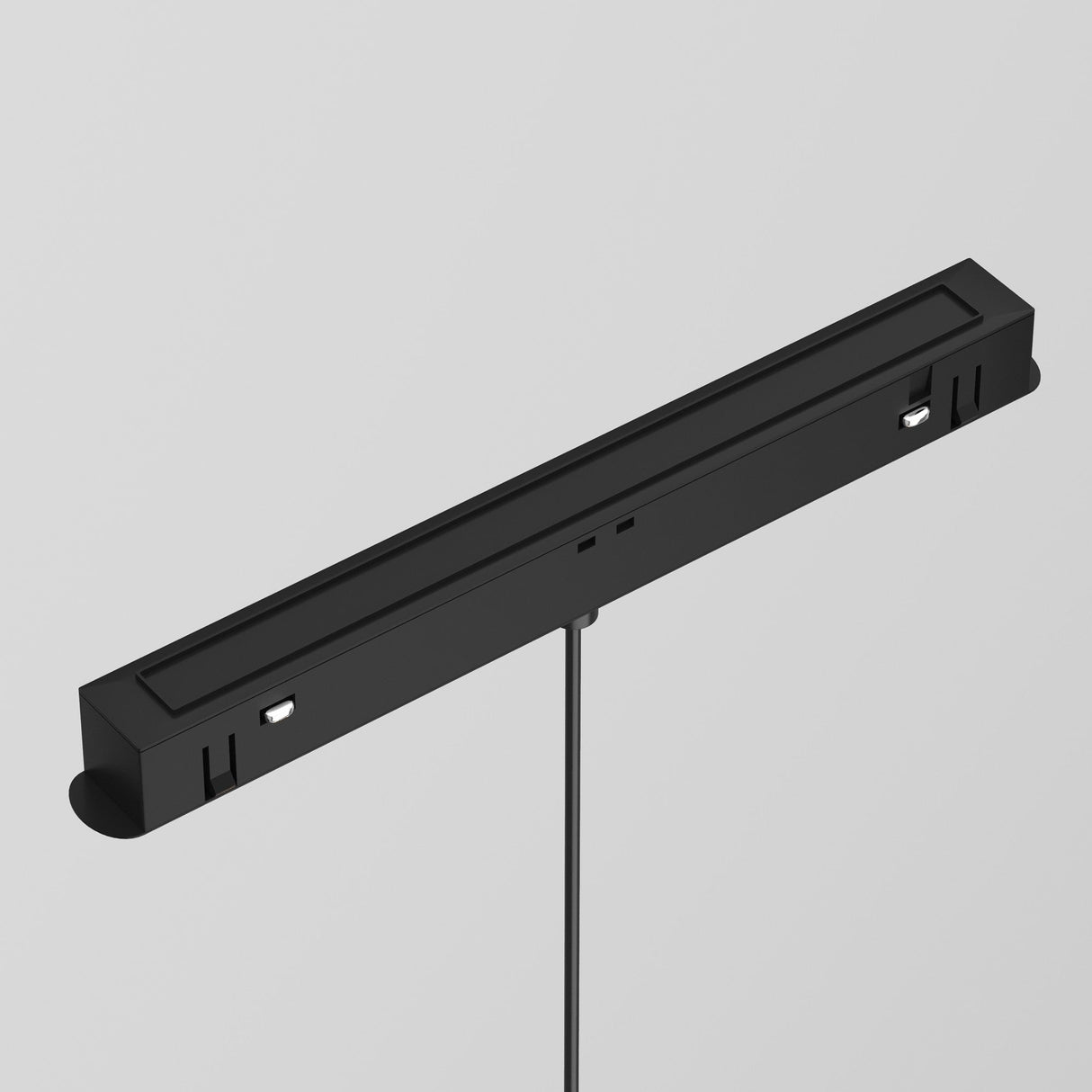 The Luna LED Exility Magnetic Track Pendant Light 5W 4000K in black features a sleek rectangular design with central wiring. It includes two symmetrically placed sensors or ports, showcasing minimalism and energy efficiency while embracing modern aesthetics against a light gray background.