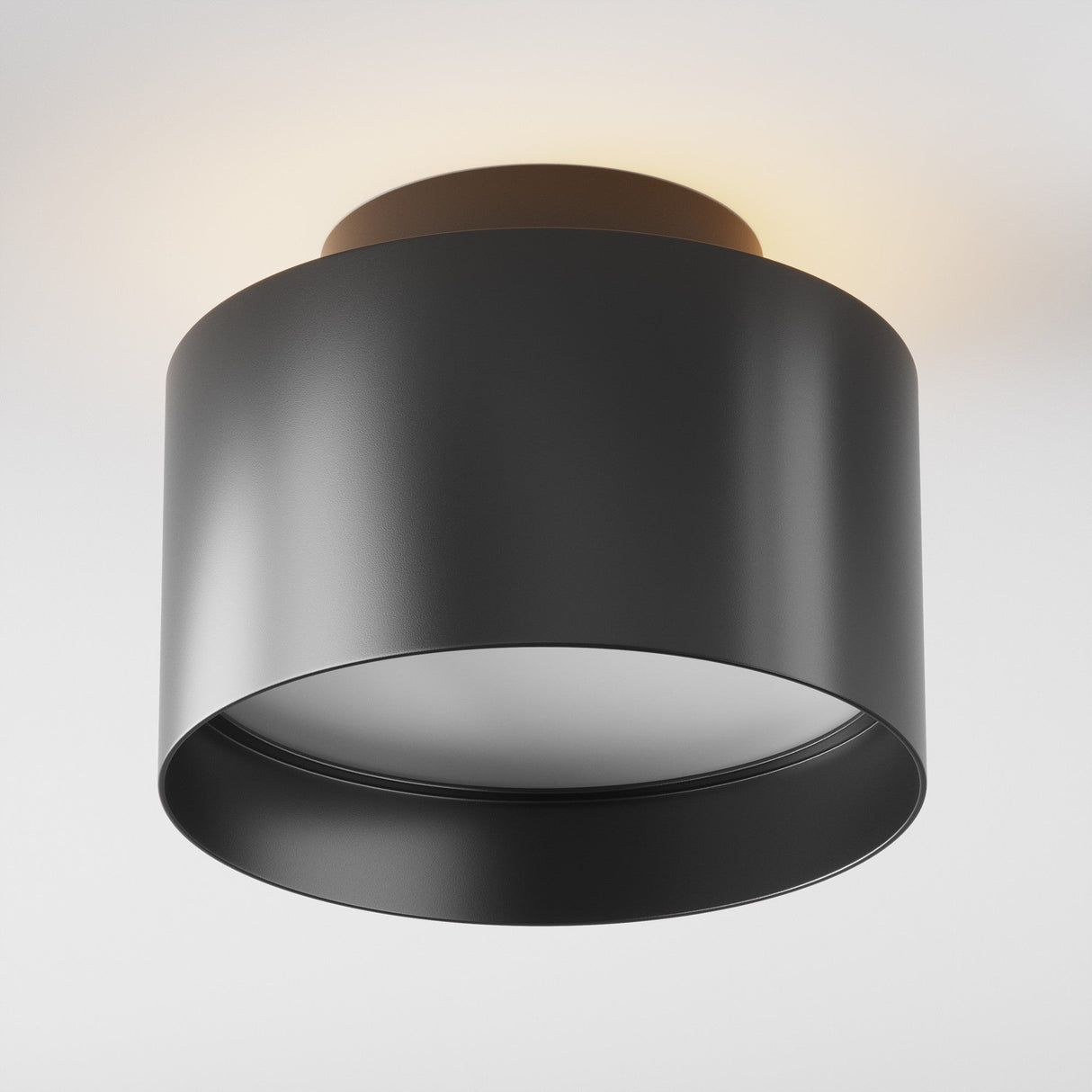 The Planet LED Medium Round Surface Downlight 3000K - Black, with its modern cylindrical design, offers energy efficiency and a sleek black finish, casting a warm subtle glow that enhances its minimalist appeal.