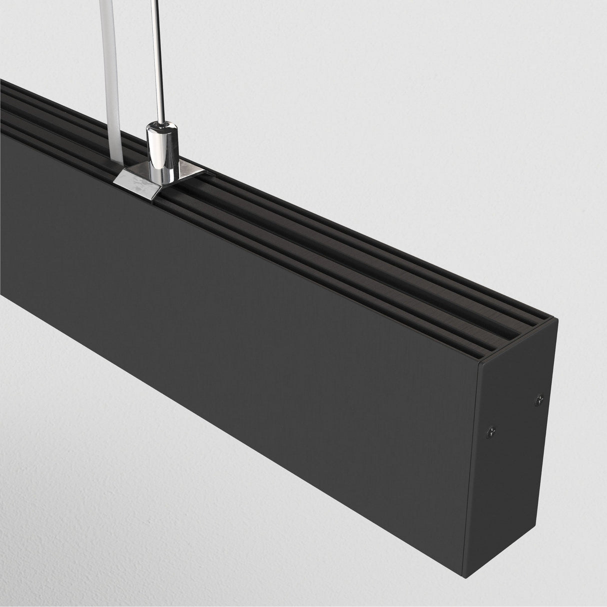 Close-up of the Points LED Linear Suspension Light in black, featuring a sleek rectangular shape suspended by thin wires. Its adjustable height and minimalist design highlight modern lighting trends with clean lines against a white background.