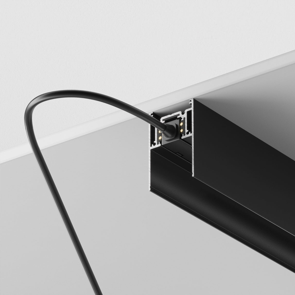 A black cable connects stylishly to the sleek S35 Magnetic Surface-Mounted Track 2m - Black, elegantly mounted on a light wall, showcasing a modern 48V lighting system with flexible configurations.