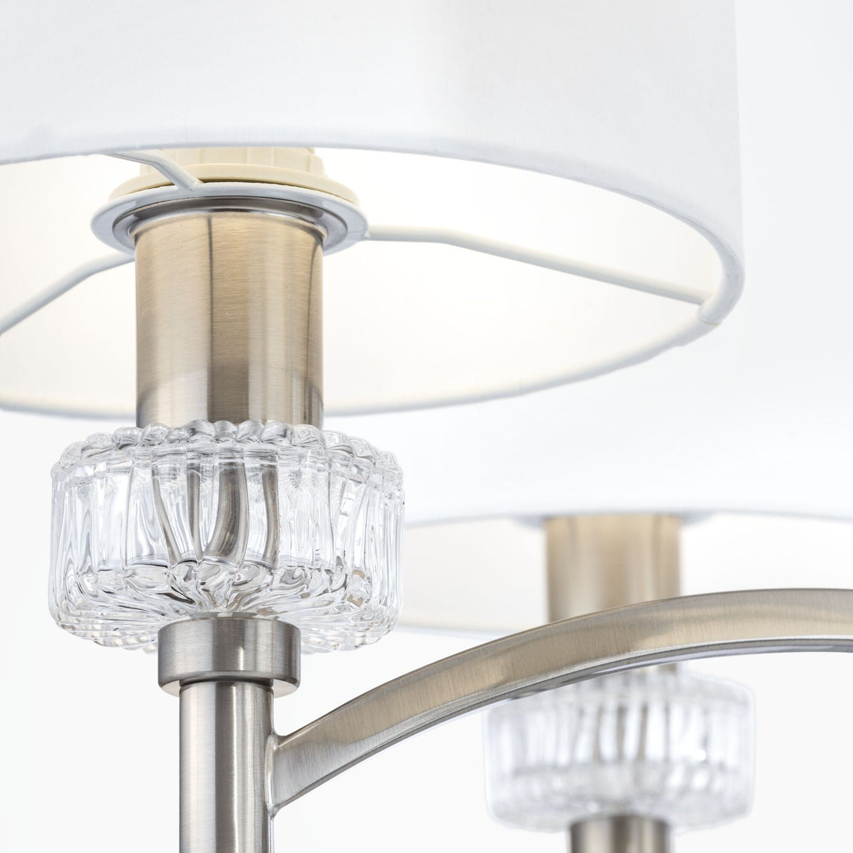 Close-up of the Alicante 6 Light Chandelier - Nickel, featuring a brushed nickel stem with two white circular shades. Perfect for modern interiors, it includes a decorative clear glass ring at each shades base, adding elegance to the design.