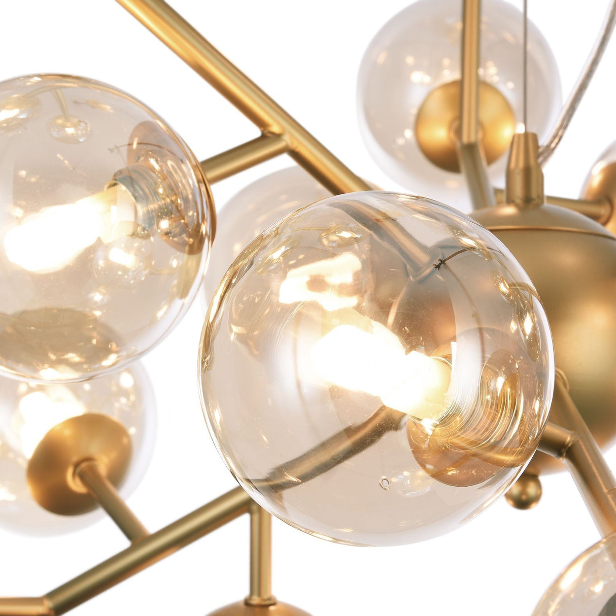 The Dallas 24 Light Chandelier in gold elegantly features spherical amber glass light fixtures with exposed bulbs, crafted from gold-colored metal intersecting rods, creating a modern and sophisticated design ideal for contemporary lighting enthusiasts.