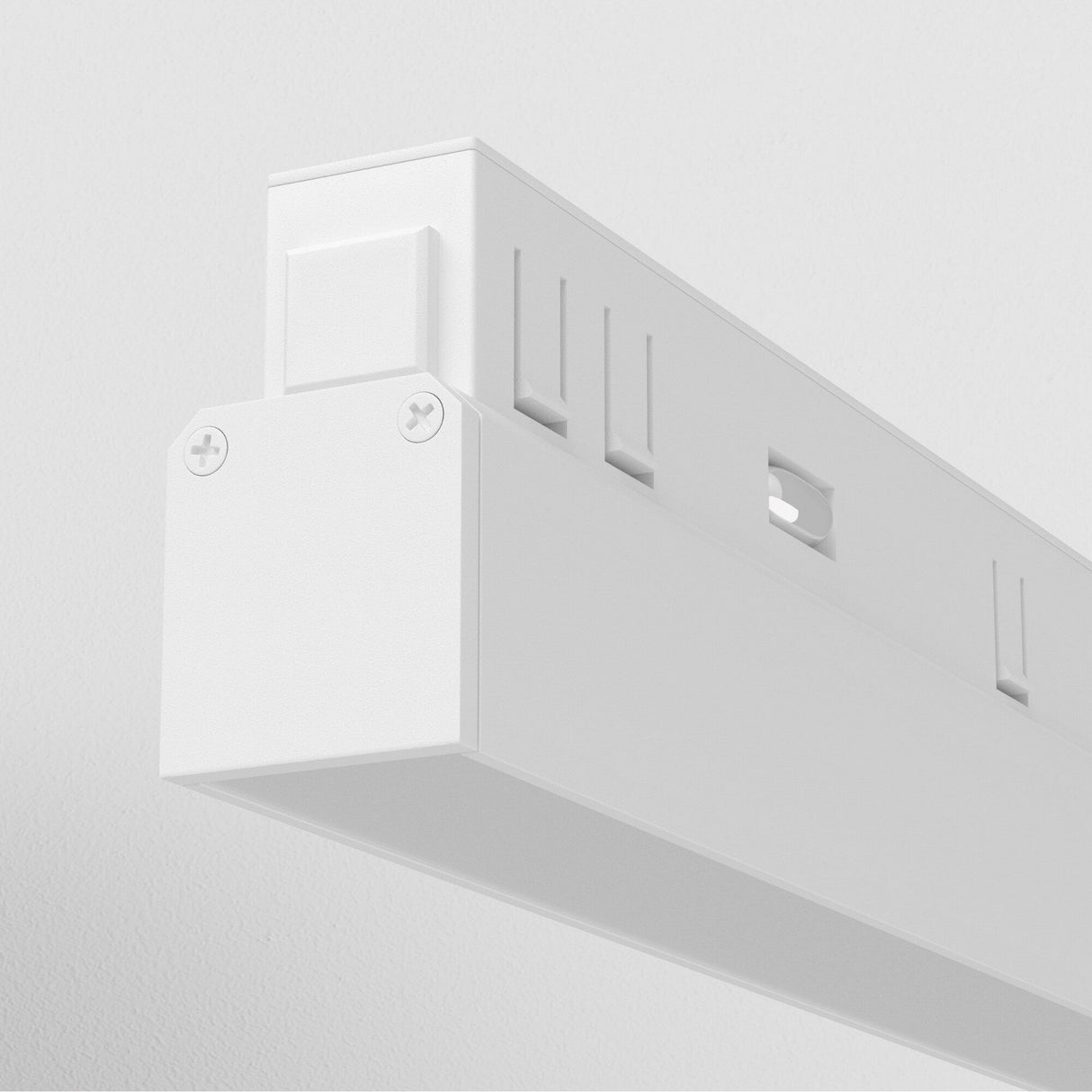 A close-up of the Basis LED Linear Track Light for Magnetic Exility 24W 4000K in white shows its sleek, minimalistic rectangular design with ridges and small screws at the ends, providing cool white light compatible with magnetic track systems for versatile ceiling installation.
