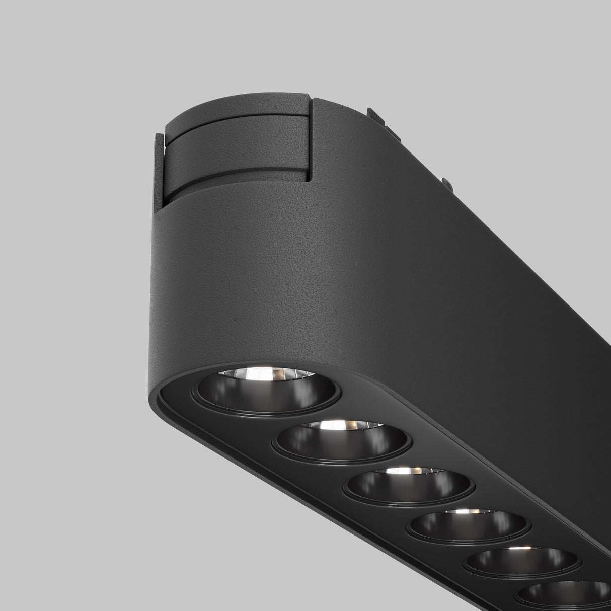 Close-up of the Points LED Linear Track Light for Magnetic Tracks Radity 12W 3000K - Black, featuring six recessed circular LEDs. Set on a plain gray background, its sleek, curved design with a matte finish makes it ideal for accent lighting.