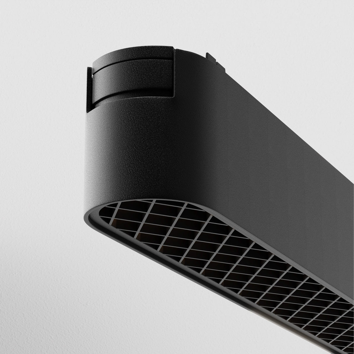 Close-up of the Basis Grid LED Linear Track Light for Magnetic Tracks Radity 12W 4000K - Black, showcasing its sleek black body with a grid-patterned underside and rounded edges. It offers ideal accent lighting on the white ceiling using modern LED technology.