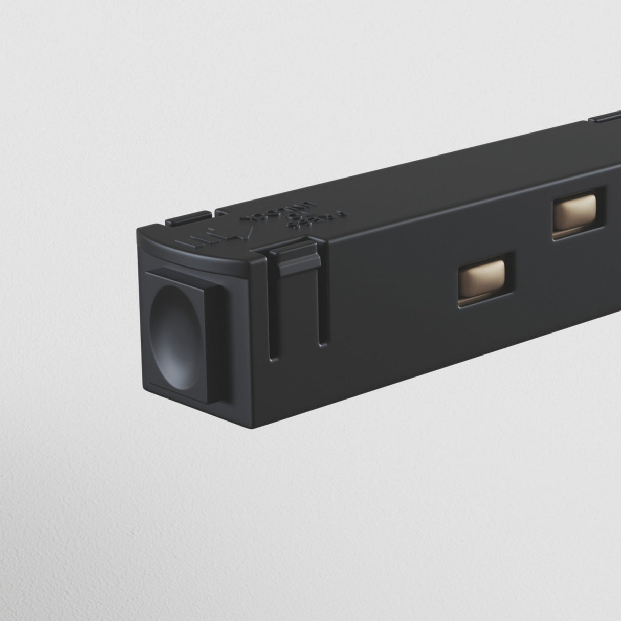 A close-up of the S35 Track Power Feed - Black features square cutouts and a rounded lens-like end, resembling track lighting components, on a plain white background.