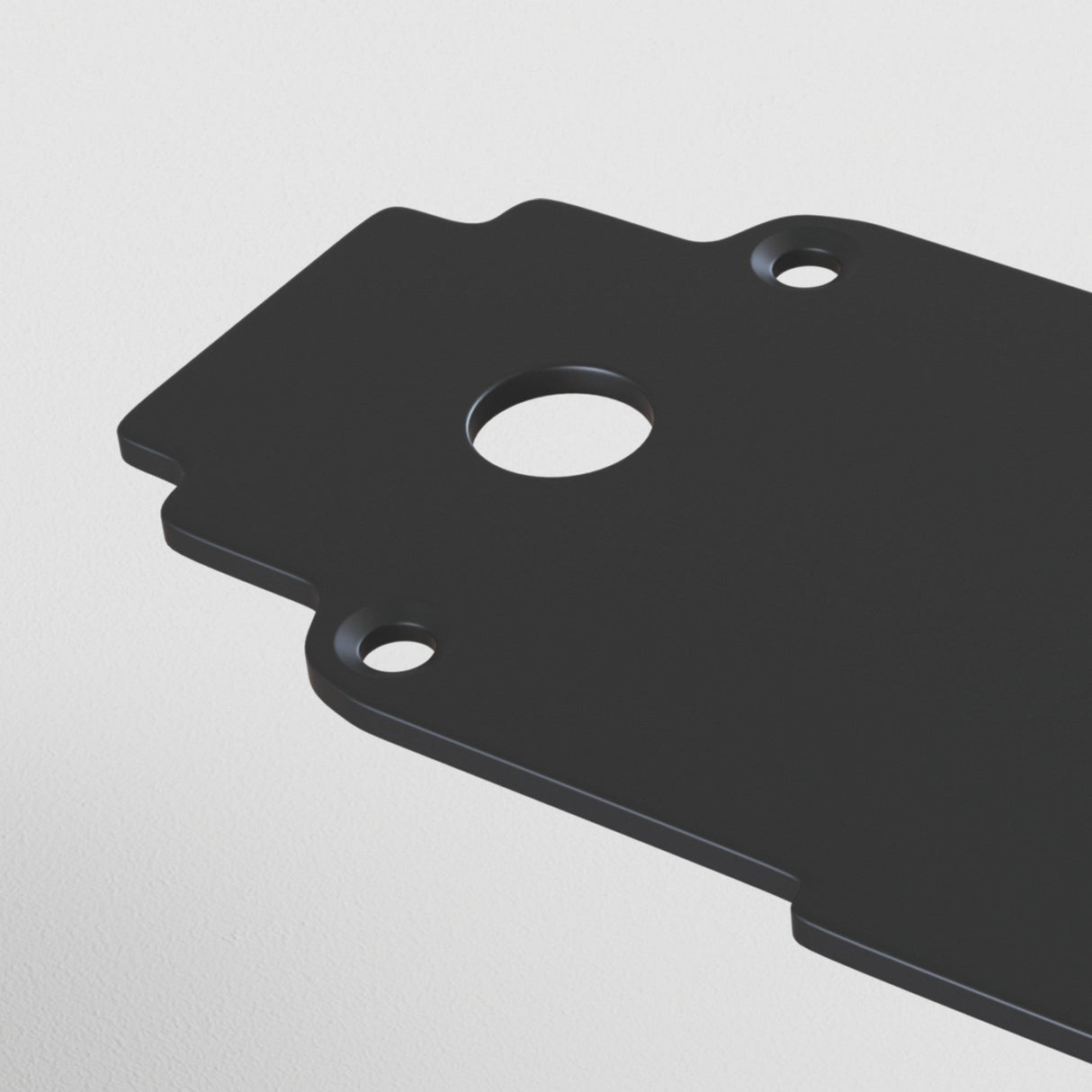 Close-up of the S35 Magnetic Tracks End Cap - Black, a rectangular metal component with a black finish, featuring three circular holes—one larger and centered, two smaller at the edges—against a plain white background.