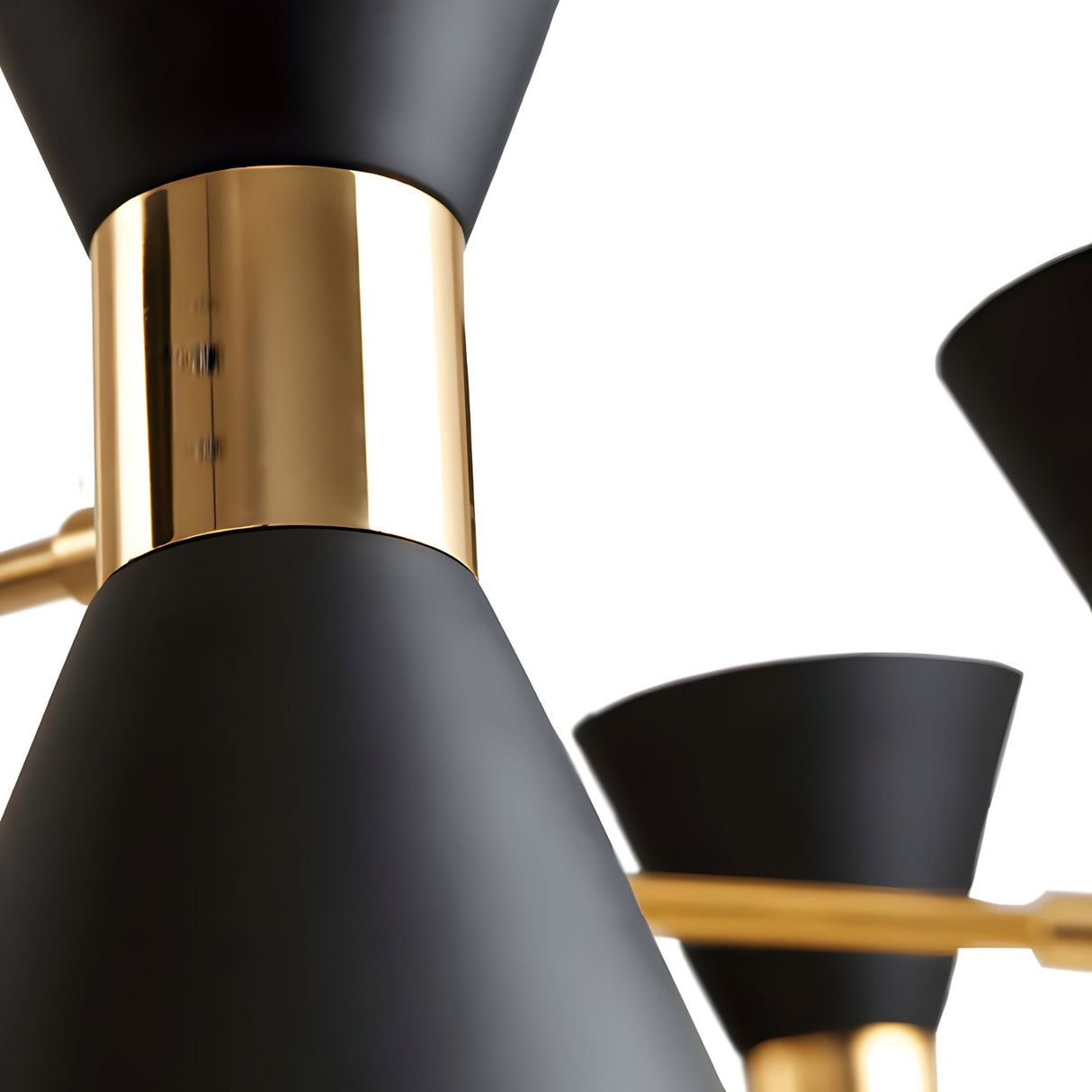 Close-up of the Ramses 3 Light Chandelier - Black, featuring matte black and shiny gold cone-shaped elements that embody modern minimalism and deliver sophisticated ambient lighting against a white background.