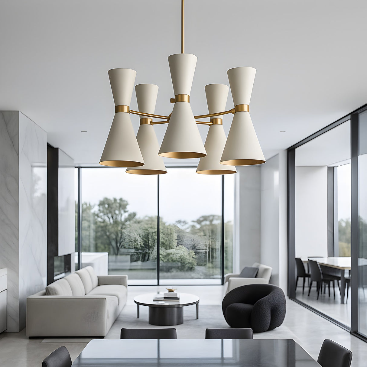 A modern living and dining space with large windows, minimalist furniture, and neutral tones features a striking Ramses 5 Light Chandelier - White as the contemporary lighting centerpiece above the dining table.