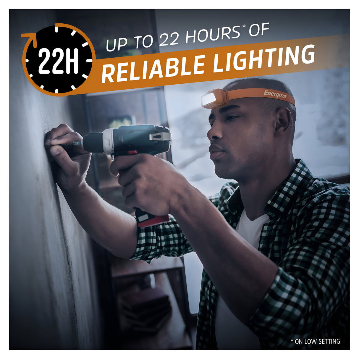A person using a power drill to fix something on a wall is seen wearing the Energizer Waterproof LED Head Torch 500 Lumen in Orange. The image highlights the head torch's features with text reading "Up to 22 hours* of reliable lighting" accompanied by a clock showing 22H, emphasizing its IPX7 waterproof protection and impressive 500 lumens brightness.