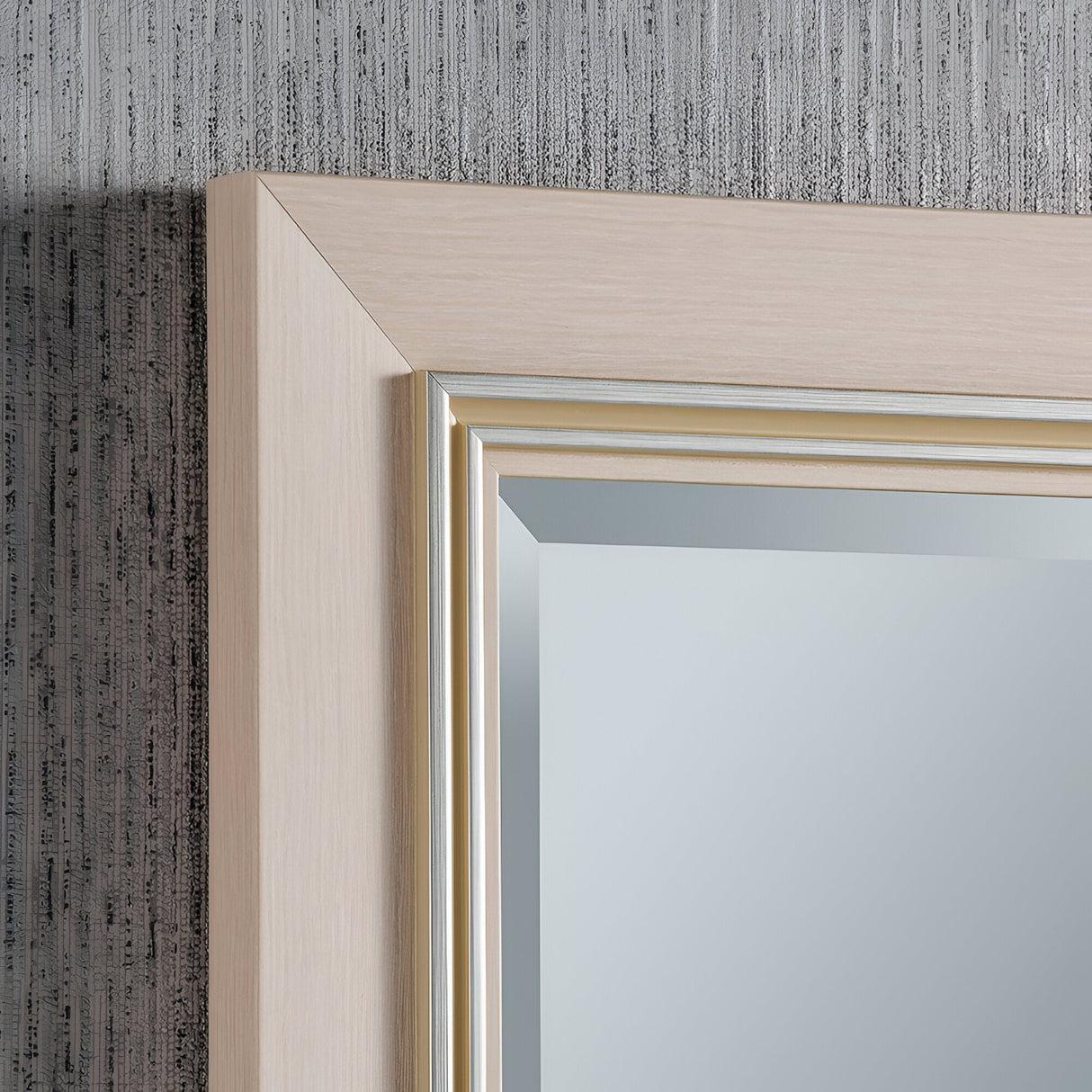 A close-up of the Alaris Rectangle Wall Mirror - White against a textured gray wall reveals its wooden frame with a light finish and subtle detailing along the inner edge, providing a chic contemporary touch to minimalist modern interiors.