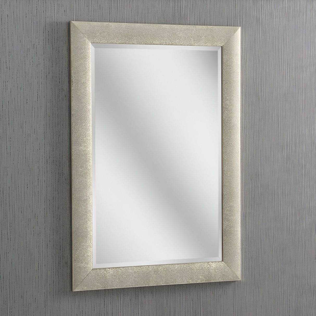 The Stardust Rectangle Wall Mirror - Champagne, with its textured frame, elegantly adorns a subtly striped gray wall. This exquisite home decor piece captures and reflects light beautifully, sitting perfectly centered in the picture.