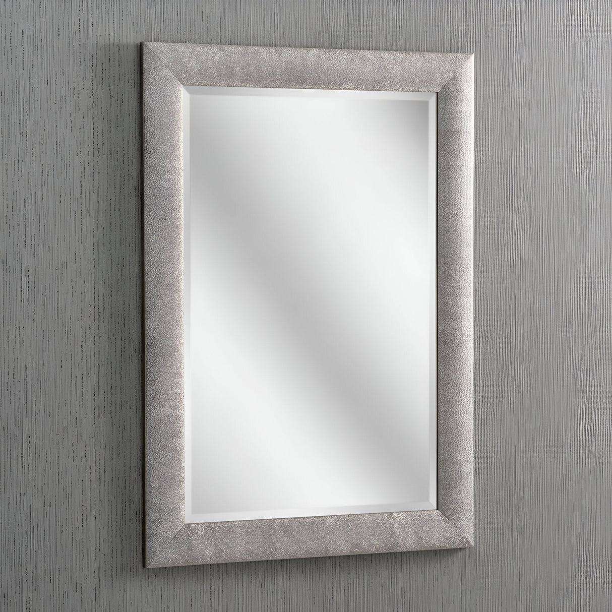The Stardust Rectangle Wall Mirror - Grey, with its textured silver and grey frame, is set against a soft gray striped background. It reflects gentle light that accentuates the clean and minimalist design.