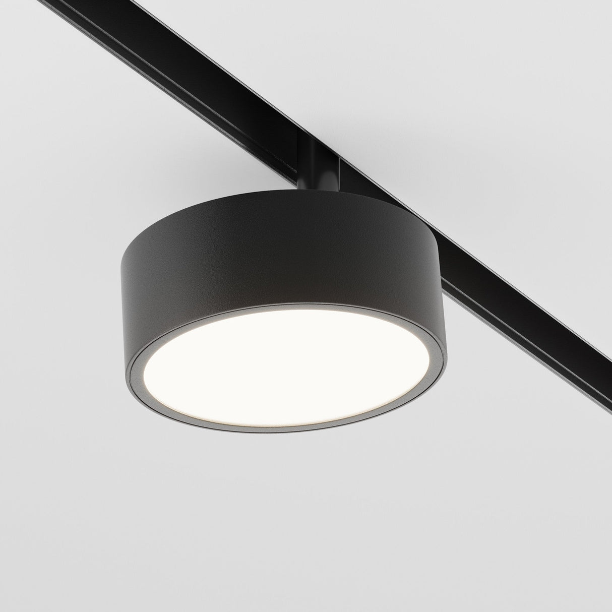 The Rado LED Magnetic Exility Track Spotlight 18W 4000K in black is a circular ceiling light with a bright white illuminated surface. It mounts on a sleek track and features energy-efficient LED technology, providing crisp 4000K light against a plain white background.