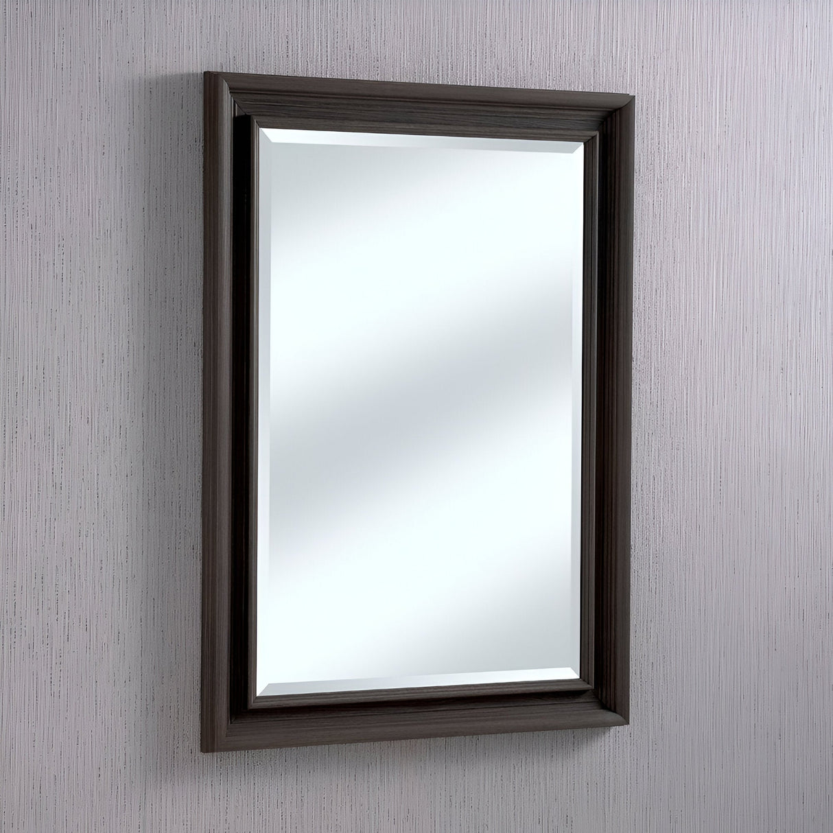 The Spiro Rectangle Wall Mirror - Coal, featuring a rectangular shape and a dark wooden frame, is mounted on a light-textured wall. The classic design of the coal frame enhances the mirror's reflection, creating a minimalist and elegant tone complemented by subtle contemporary design elements.