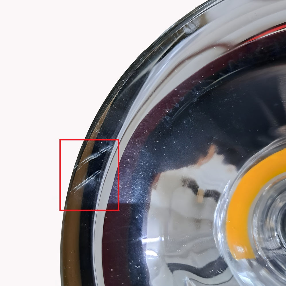 Close-up of the Ex-Display Gulf Pendant Light - Silver with a prominent scratch highlighted by a red rectangle. The silver finish gleams as reflections dance across its surface, accentuating the orange side marker against a pristine white backdrop, reminiscent of modern interior decors elegance.