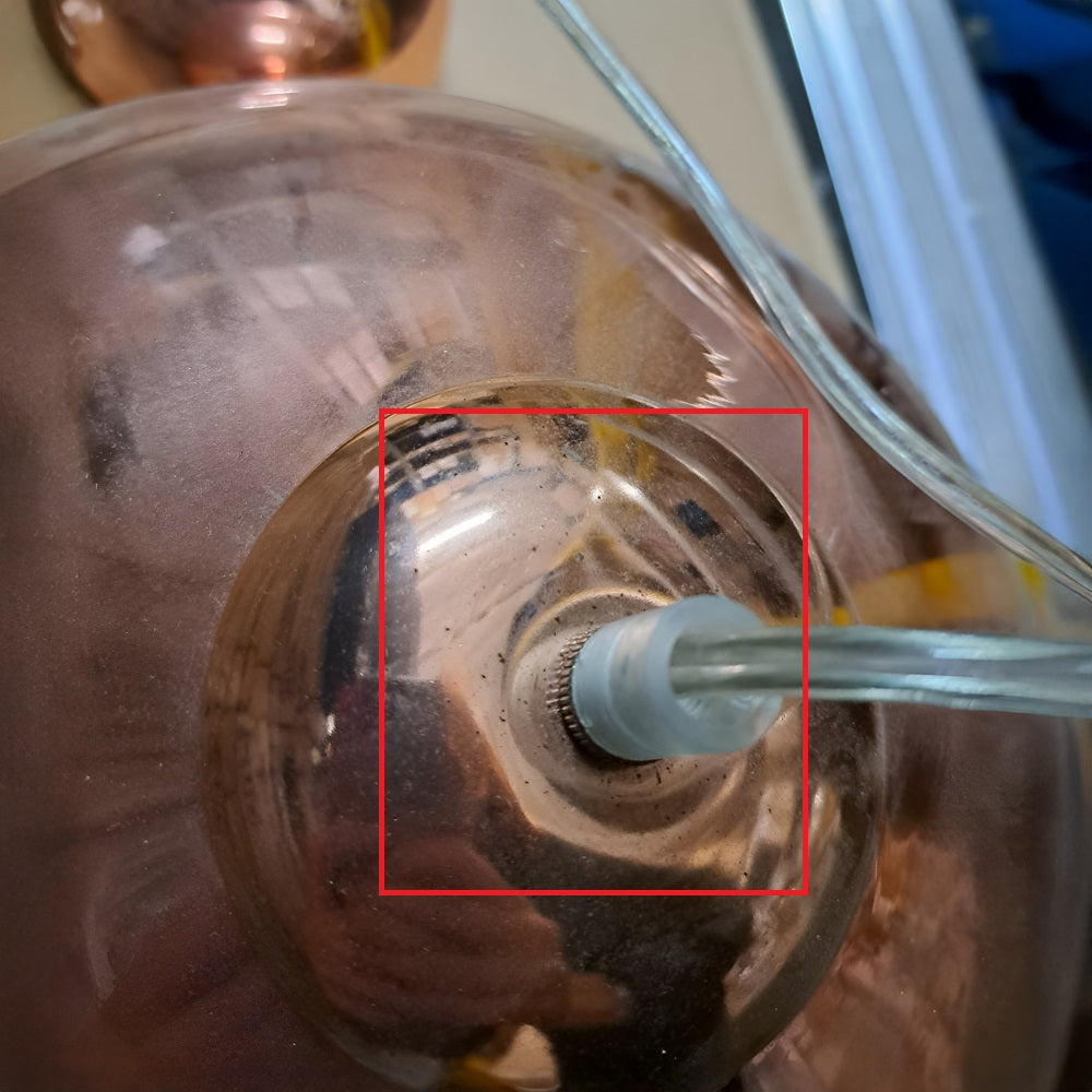 Gazing inside the metal kettle, the metallic grey rim and limescale contrast with the glistening heating element and water level marks. The stains reflect a warm light reminiscent of an energy-efficient bulb, perfectly complementing an Ex-Display Gulf Pendant Light - Copper.