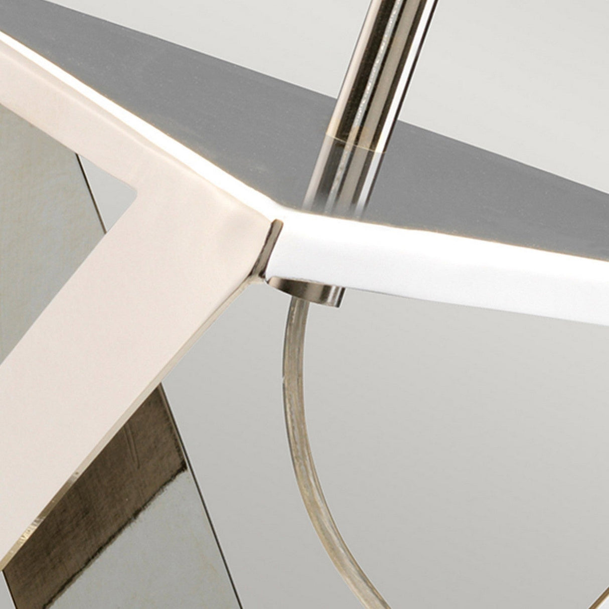 Close-up of the Aegeus 1 Light Table Lamp with its modern, polished nickel design featuring sleek, angular edges and a reflective surface. The glossy metal supports and transparent cable accentuate its contemporary style against a smooth, neutral gray background.