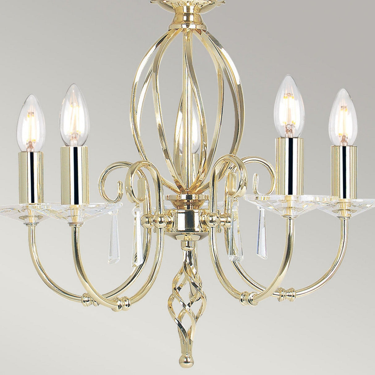 Introducing the Aegean 5 Light Chandelier in polished brass, featuring five candle-shaped bulbs and decorative crystal accents, embodying an elegant, intricate design.
