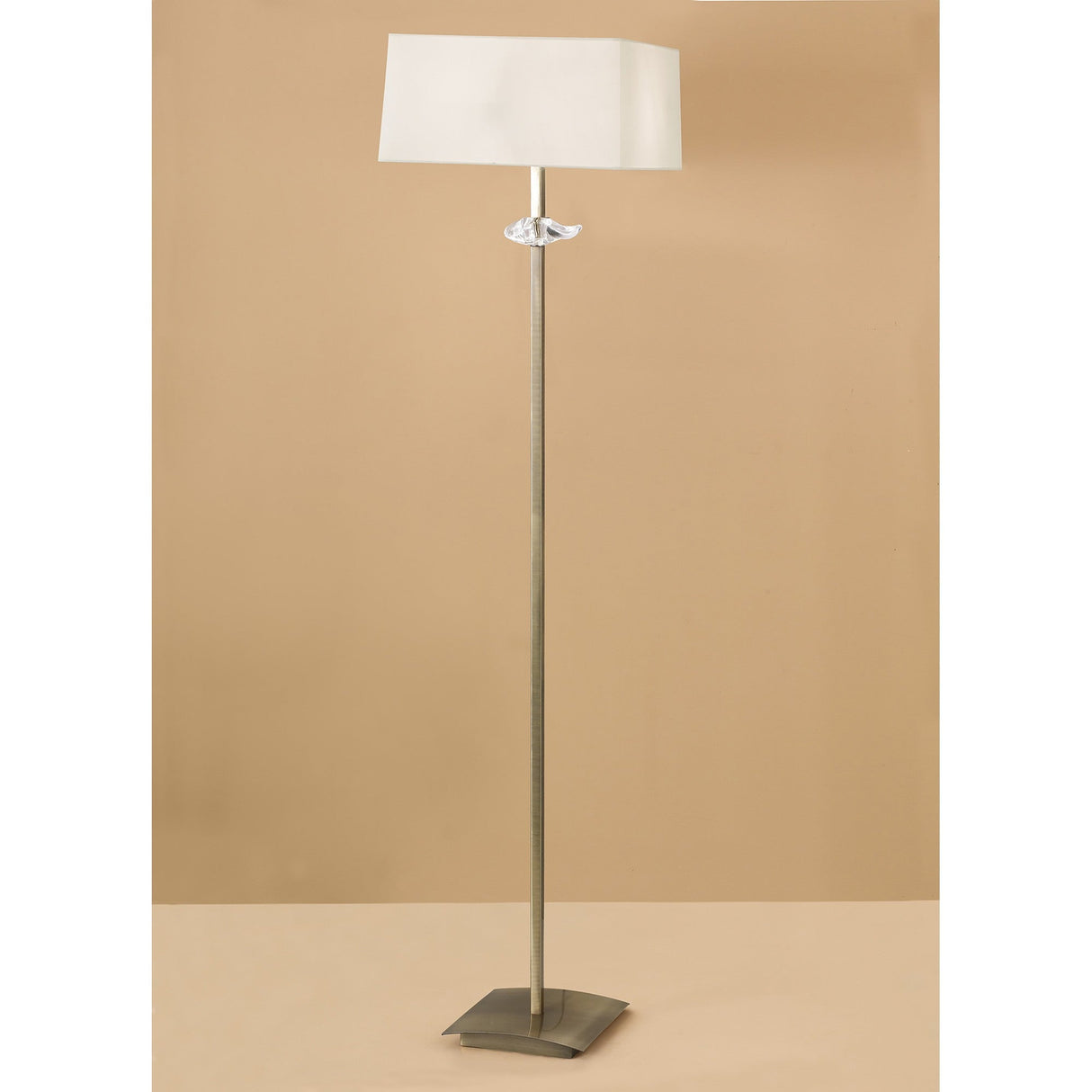 The Akira 3 Light Floor Lamp features a slim antique brass stand, clear accent, cream rectangular shade, and square base, providing ambient lighting and modern style.