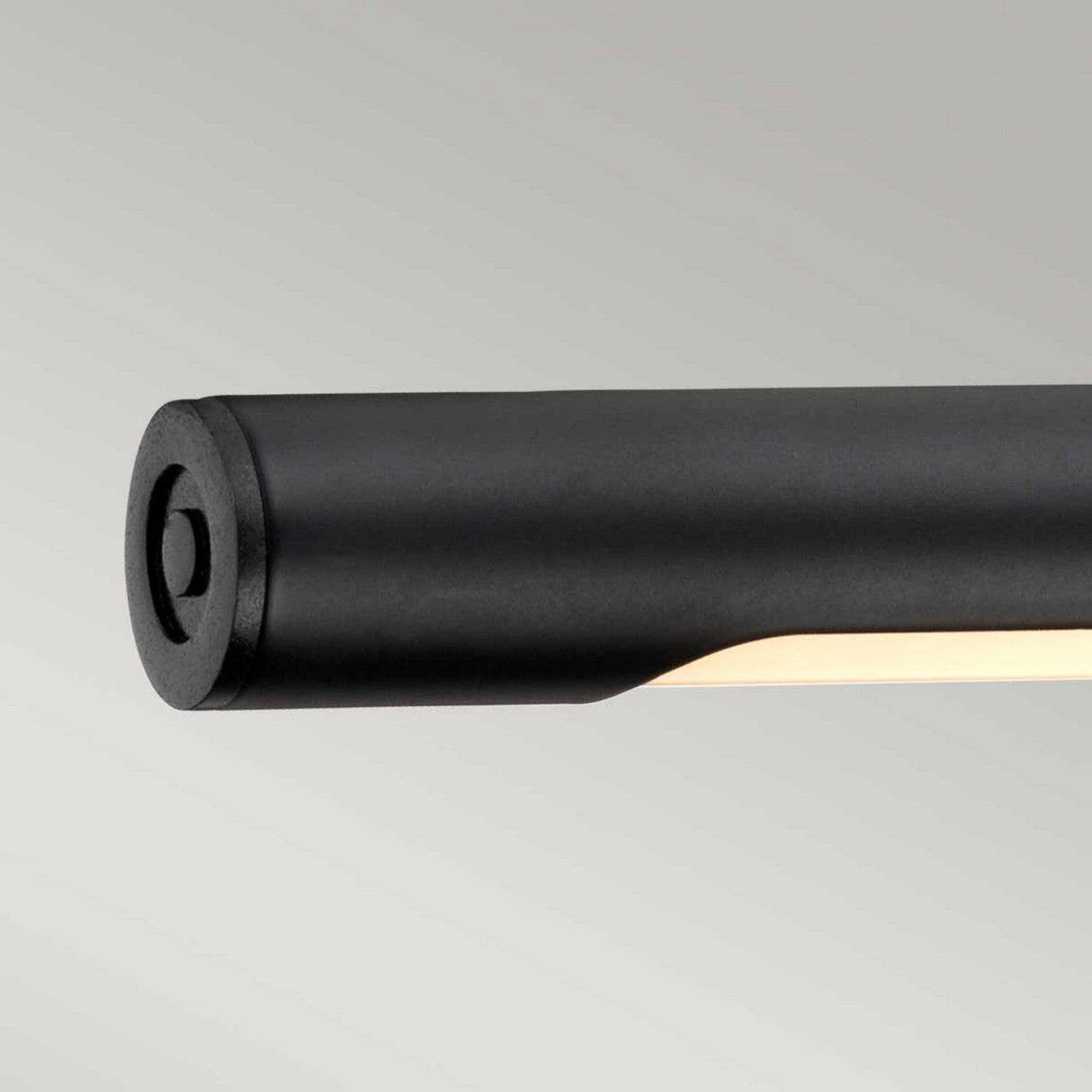 Close-up of the Alton 1 Light Large LED Picture Light in black, mounted horizontally against a light gray background. With its adjustable design, this sleek and minimalist LED wall light partially illuminates, showcasing its modern cylindrical shape.