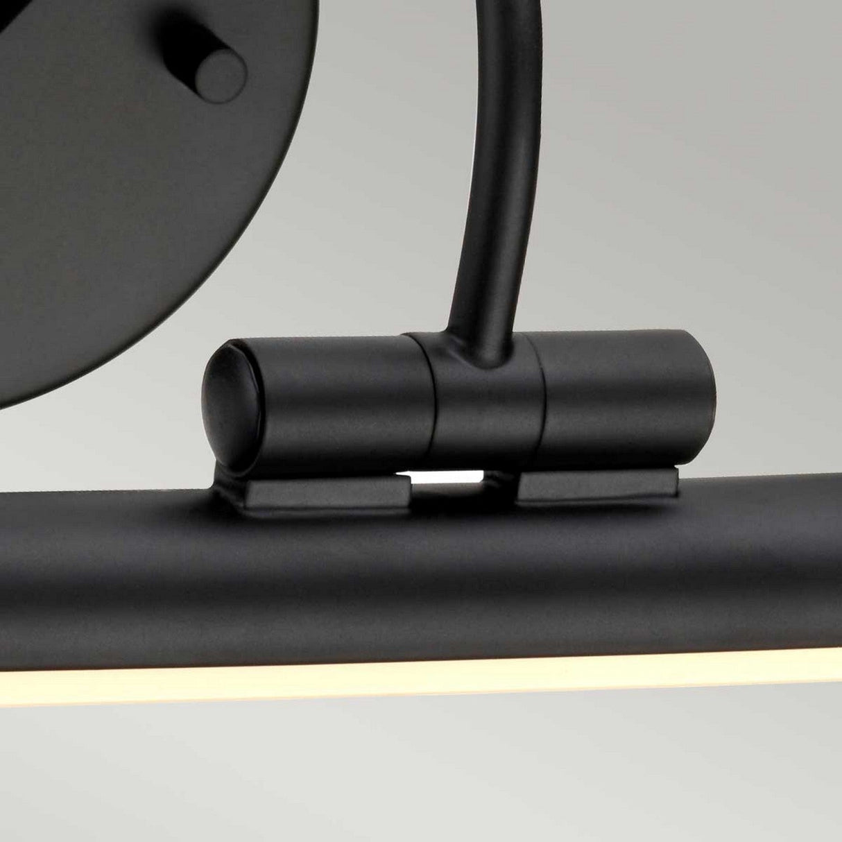 Close-up of the Alton 1 Light Small LED Picture Light in black, showcasing its modern cylindrical design. This fixture features a minimalistic matte black finish and emits a soft, diffused light from the bottom, making it ideal for art illumination.